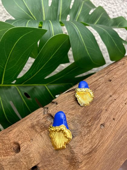 Artful curves and everlasting charm. These modern gold-plated studs feature a unique folded design with a pop of royal blue enamel.