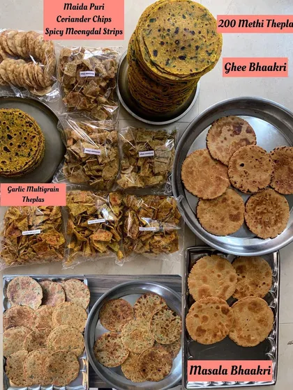 A traveler's dream pack. This order includes a variety of breads like 200 Methi Theplas, Ghee Bhaakri, and Masala Bhaakri, along with assorted dry snacks like Maida Puri and Spicy Moongdal Strips.