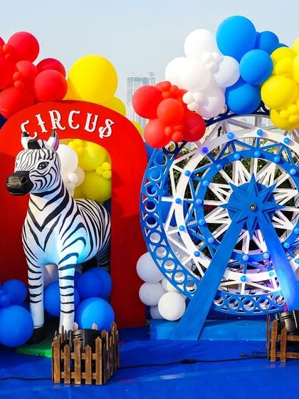 A close-up of the circus stage decor, featuring a light-up ferris wheel, a zebra, and a lion prop.