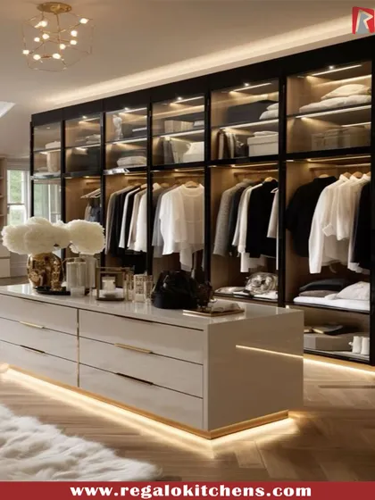 High-gloss white finishes and herringbone wood floors give this walk-in closet a chic and polished look. The central island includes illuminated base lighting, adding a soft glow to the space.