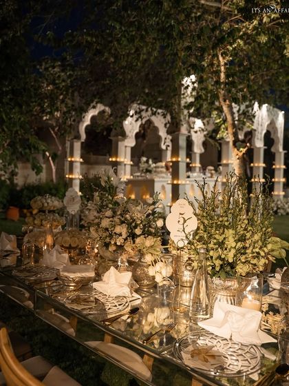 A detailed tablescape from the 'Sheesh Mahal' reception, showing how mirrored surfaces and all-white florals create a feeling of pure opulence.