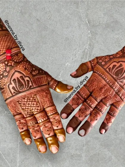 A detailed back-hand design with a mix of lotus motifs, grid patterns, and traditional borders. The small rakhi tied on the wrist adds a personal touch.