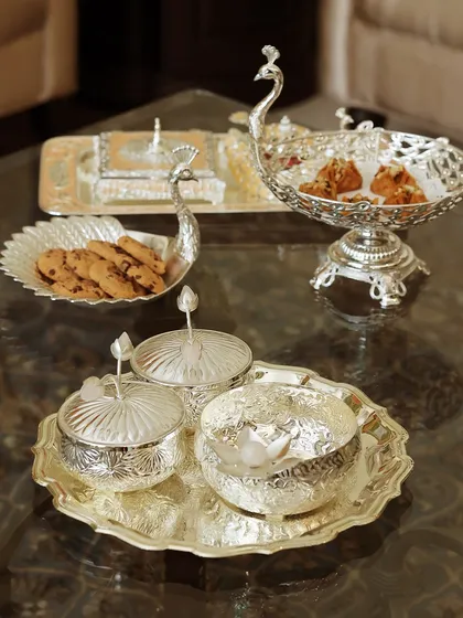 Hosting is an art form, and my Mijaaz Collection is its grand expression. This peacock-themed silver-plated serveware captures the essence of Mughal artistry, turning every gathering into a royal affair with its majestic charm and intricate detail.