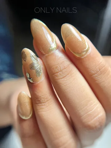 A close-up view of the golden cat eye nail art. You can see the detail of the gold foil accent and the clean line of the chrome French tip, creating a rich and textured look.