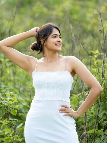 A serene portrait of a model in a simple white dress, surrounded by nature. This shot has a very pure and organic feel, perfect for lifestyle or wellness brands.