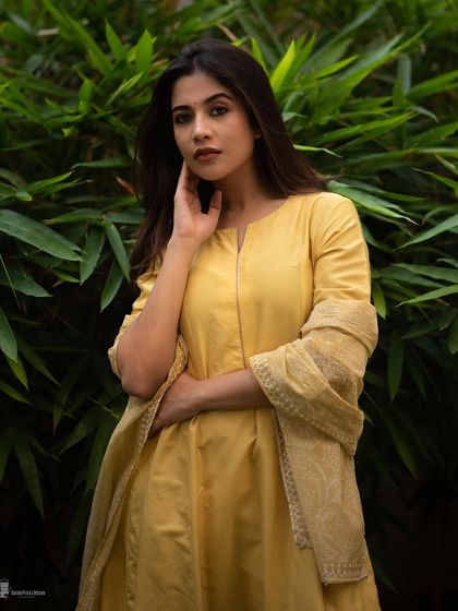 A classic portrait using the soft, even light of an overcast day. The subject's traditional attire against the simple green background creates a timeless and elegant look.