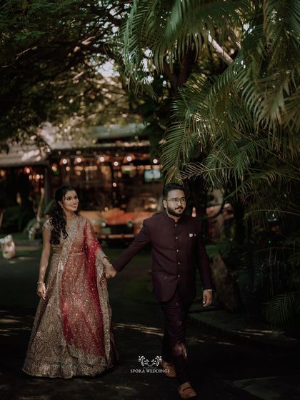 The couple walking hand-in-hand at dusk, the warm lights of the venue creating a romantic and magical atmosphere for their reception.