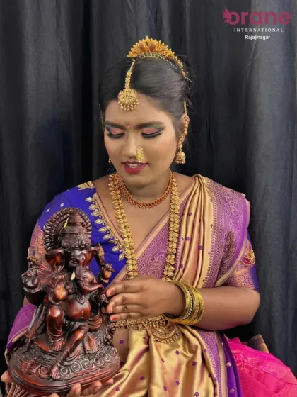 A beautiful festive hairstyle created for a Gowri Ganesha celebration. The hair is styled in an elegant bun, adorned with traditional hair jewelry, showcasing the skills our students learn for special occasions.
