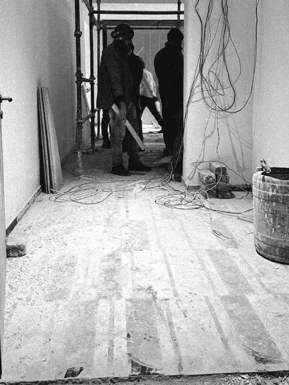 A corridor in progress. The flooring pattern is being laid out, and the space is starting to transition from a construction site to a designed interior.