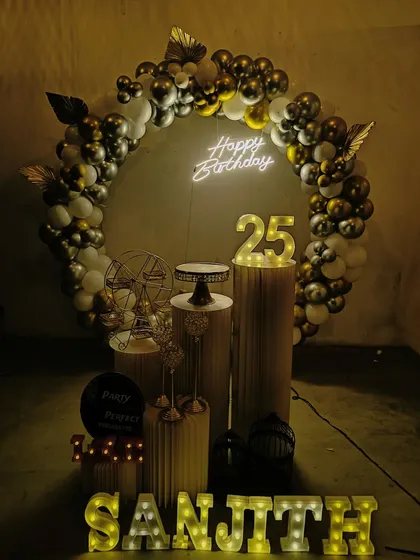 I create moody and stylish setups for milestone birthdays, like this 25th celebration. The decor uses a dark, sophisticated color scheme with a gold and black balloon arch, a neon sign, and light-up numbers and name for a cool, modern vibe.