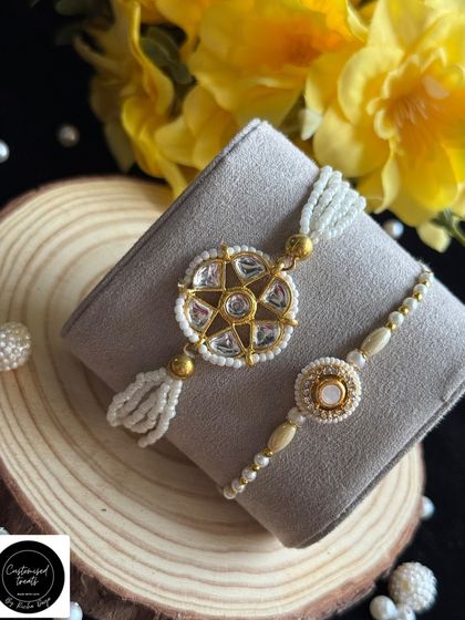 This classic Kundan-style Rakhi set exudes timeless elegance. The intricate stonework and pearl detailing create a luxurious look for both the Lumba and the matching brother rakhi.