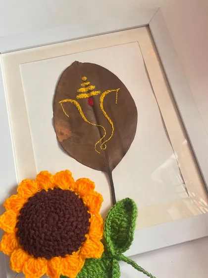 A close up of the framed Ganesha leaf embroidery, next to one of my crochet sunflowers. I love mixing different handmade textures together.