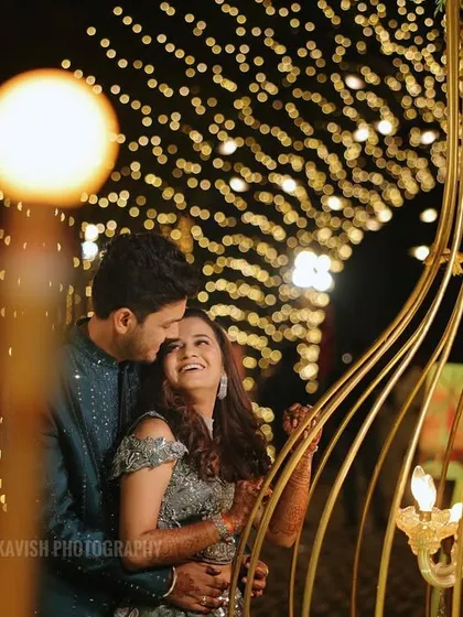 A romantic sangeet portrait with beautiful bokeh from the fairy lights, highlighting the couple's joyful interaction.