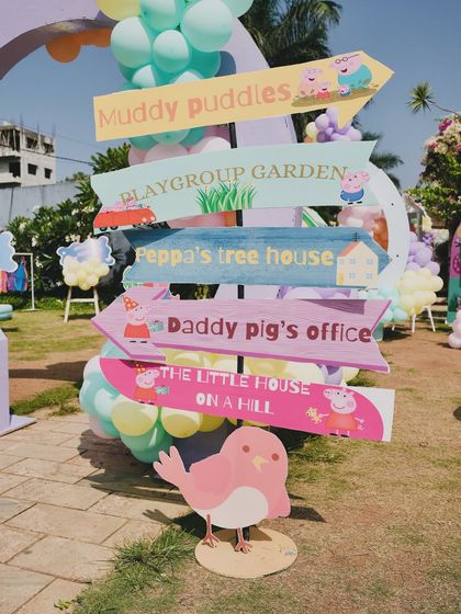 A fun and thematic signpost from the Peppa Pig party, pointing the way to famous locations like "Muddy Puddles" and "Daddy Pig's Office."