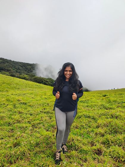 A happy trekker enjoying the lush green meadows of Kudremukha. The feeling of walking through these fields is truly liberating.