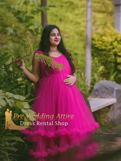 This dark pink ruffled gown offers a rich, vibrant color for your maternity portraits. Photographed in a lush garden, the dress's full tulle skirt provides a beautiful contrast with the natural surroundings.