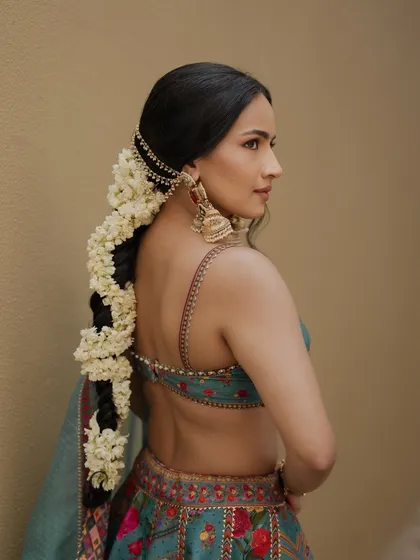 A close up showing the intricate details of the bride's floral jewelry and her flawless, natural looking makeup.
