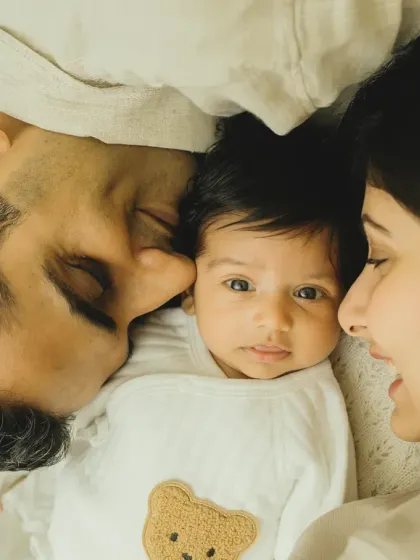 An intimate overhead shot of new parents admiring their baby. This perspective creates a feeling of being right there in that loving moment.