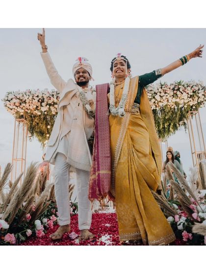 The happy couple, Nikita and Shriyansh, celebrating their union with hands raised in the air.