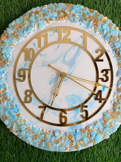 This clock features a soft blue marble effect with a border of blue and gold crystals. It's a beautiful example of how to combine different textures in resin art.