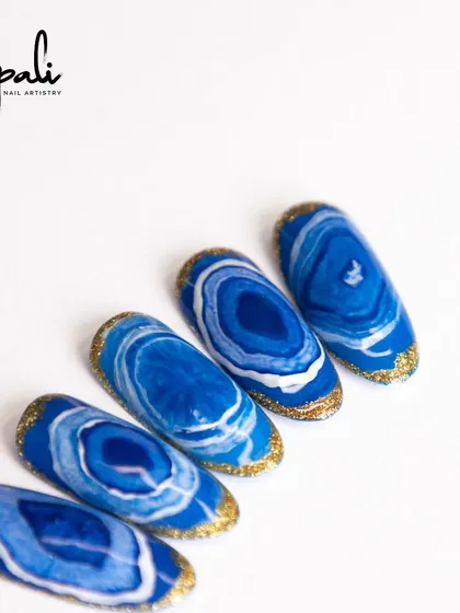 This "sea effect" design is a variation of marble art, creating patterns that resemble ocean waves and agate stones.