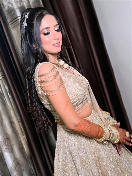 The side profile shows off the beautiful details of her hairstyle, complete with delicate accessories and cascading curls.