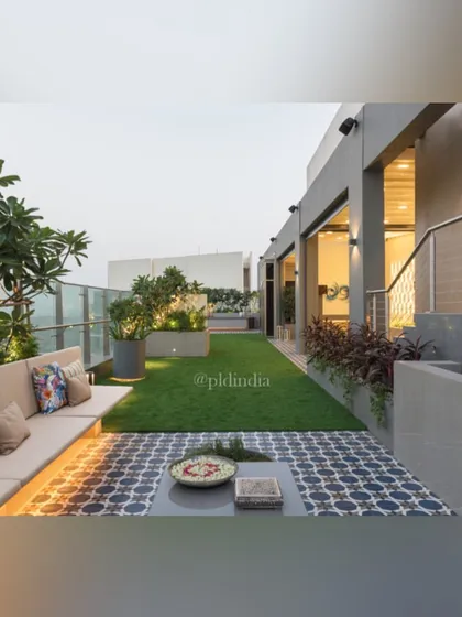 This view shows the transition from the indoor space to the terrace garden. The large glass doors slide away to connect the living area with the lawn and seating outside, creating a perfect indoor-outdoor flow.