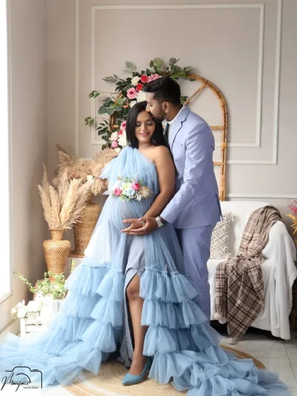 A tender kiss on the forehead in this romantic couple's portrait. The light blue gown and suit create a soft and elegant color palette.