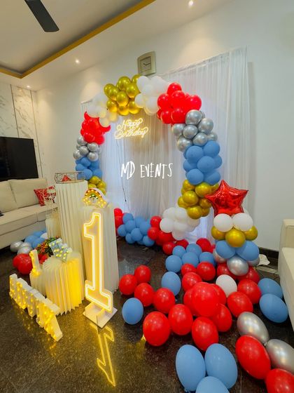 A wide-angle view of the red, blue, and gold first birthday decoration, showing how the balloons fill the space and create a festive atmosphere in the home.