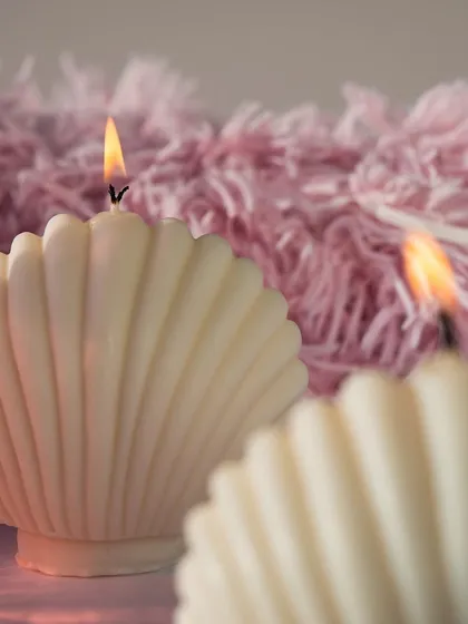 Our beautiful oyster shell candles, lit against a soft pink background. These bring a touch of coastal calm and elegance to any room.