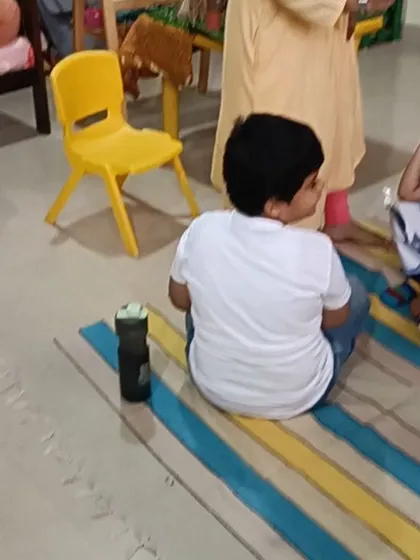 A child listens with a hand on his chin, deep in thought about the story.