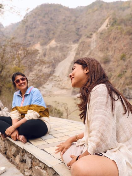 Candid laughter and conversation by the river. These unscripted moments of sharing and connection are where the true magic of the sangha happens.
