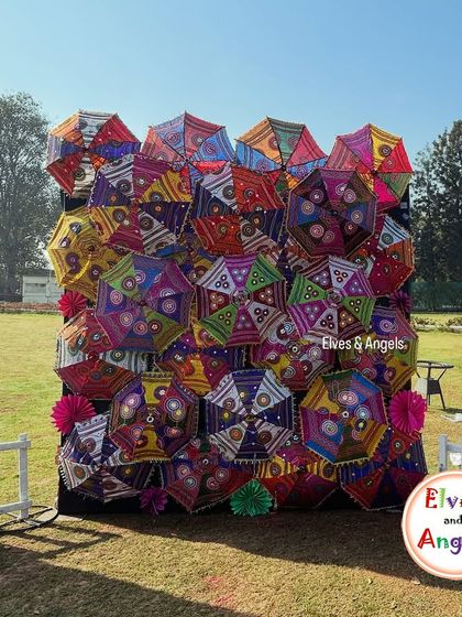 The full view of the vibrant umbrella wall I created for an outdoor Holi event. It's a perfect example of how I use unique props to create memorable decor.