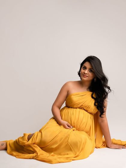 A relaxed, seated pose in a vibrant yellow drape. This shows that you can be both comfortable and stunningly beautiful in your portraits.