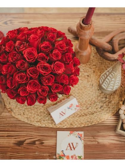 A top-down view of a table centerpiece. We layer textures and elements like custom stationery, floral arrangements, and traditional beads to make every detail feel intentional.