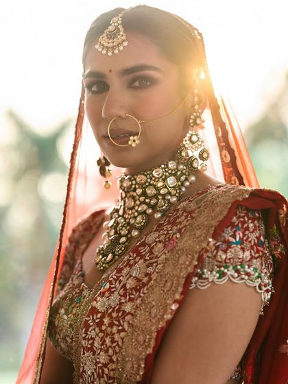 A sunlit portrait of a bride, her hair in a neat updo, creating a halo effect.