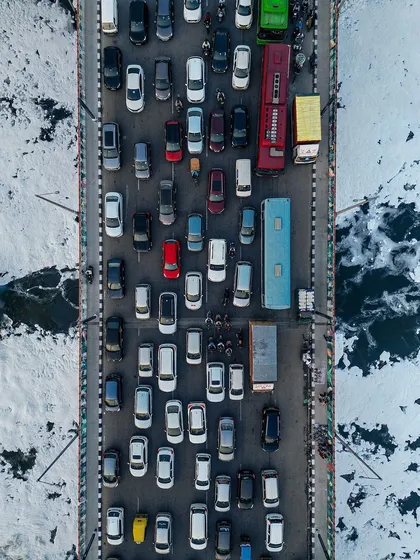 From above, the infamous Delhi traffic transforms into a work of art. This top-down aerial photo captures the chaotic yet colorful pattern of cars on a bridge over the Yamuna, finding a moment of organized beauty in the city's constant motion.