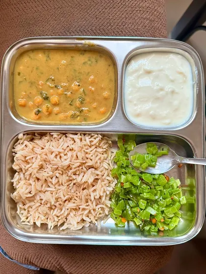 A comforting plate of brown rice, channa dal, sautéed beans, and curd. This is a classic Indian meal that is both healthy and filling.