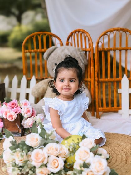 A sweet close up of the birthday girl during her outdoor session. Her simple white dress and the soft floral props create a pure and innocent look.