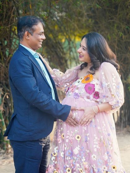 A happy outdoor moment for the expecting couple. The natural setting and their joyful expressions make for a warm and authentic portrait.