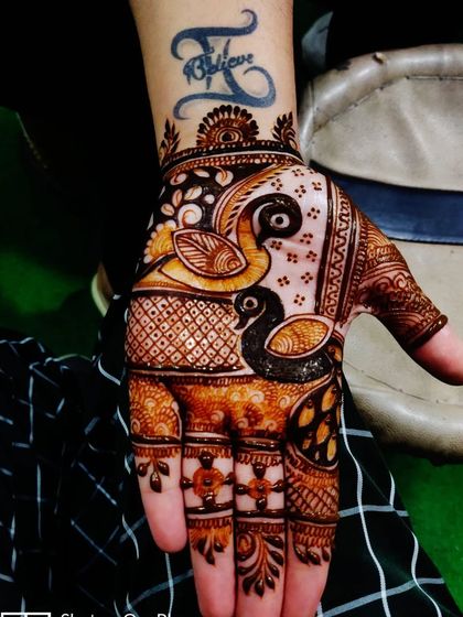 A modern take on a traditional design, this hand mehandi features two swans. The design is applied around an existing tattoo, showing how I can customize the art for you.