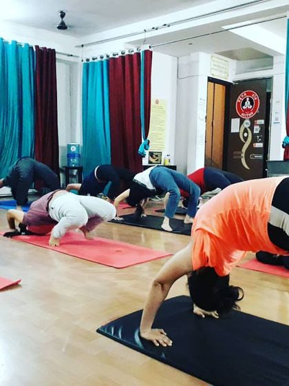 Students at different stages of entering Chakrasana (Wheel Pose). I guide each person to work within their capacity, using props and preparation to build up to the full expression of the pose.
