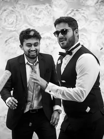 A candid black and white shot of the groom and his friends enjoying the Sangeet party, capturing the genuine fun and camaraderie of the celebration.