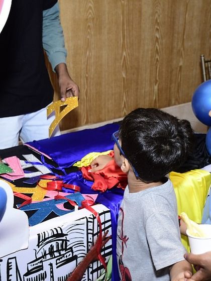 Little guests curiously checking out the cape-making station. The setup is designed to be inviting and exciting for the kids.