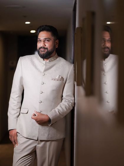 A dapper portrait of the groom at his reception, captured with elegant lighting.