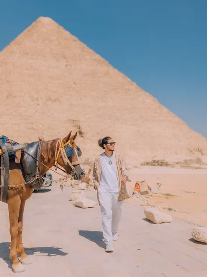 A candid moment walking past a horse near the pyramids in Egypt. This image captures the blend of ancient history and the living, breathing culture of the place.