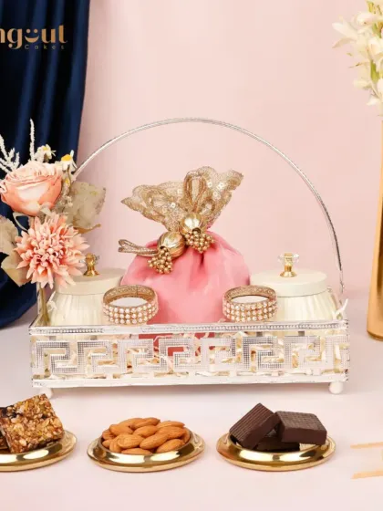 Elegance finds its perfect place in the Modita premium Diwali hamper. The delicate silver tray holds beautifully wrapped potlis and jars of treats, complete with floral accents for a sophisticated festive gift.