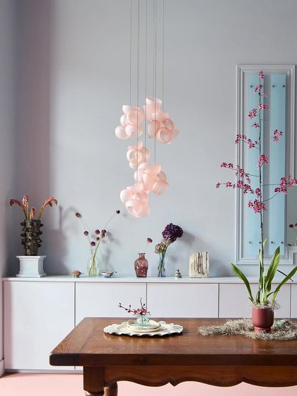 A beautiful installation of the pink Bocci 100 series over a dining table, its soft light creating a perfect atmosphere for an intimate meal.