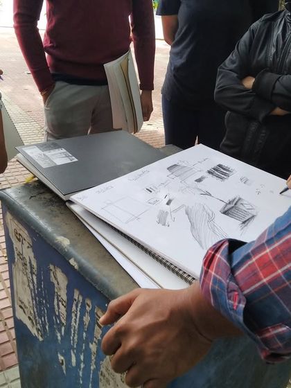 A throwback to our 2019 plein air sessions at Cubbon Park, where an instructor demonstrates shading techniques on a public dustbin.