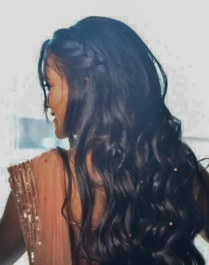 A beautiful shot from behind, focusing on her long, flowing curls and the delicate details of her outfit.